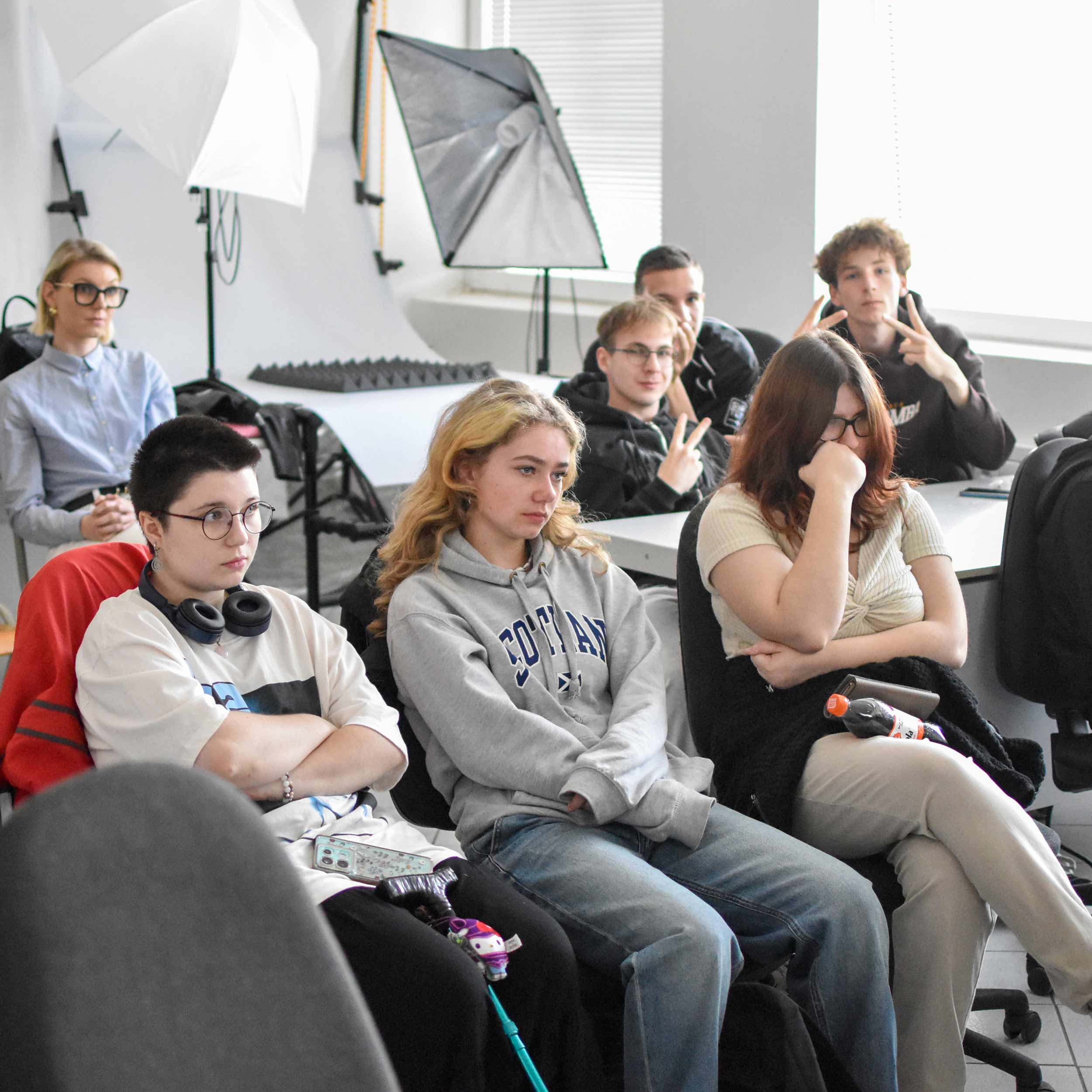 Študenti multimédií sústredene sledujú prednášku „Od študenta k profesionálovi“ na SOŠ Púchov; v pozadí vidno fotografické softboxy.